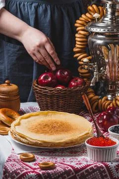 Pancakes on the table with traditional patterns, next to the samovar and ca.. 스톡 사진