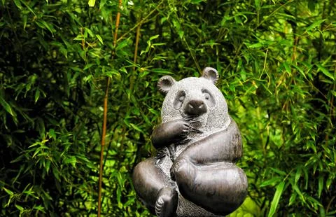 Panda figurine. against the backdrop of beautiful nature. trees and bamboo. Photos