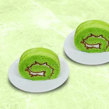 Pandan rolled sponge cake on a white plate Stock Photos