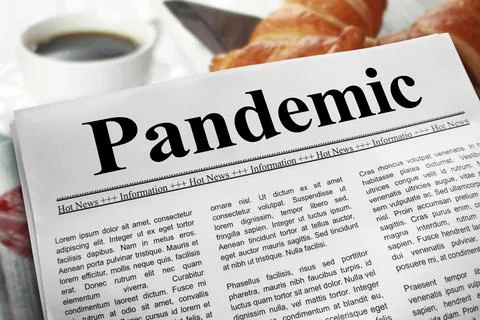 Pandemic in newspaper layout on a breakfast table with a blurry cup of coff.. Stock Photos