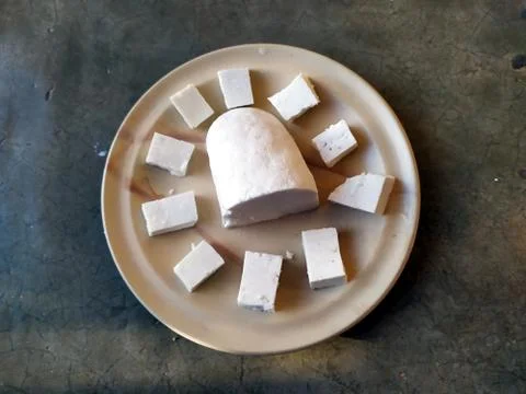 Paneer slice put in a plate with stone background Stock Photos