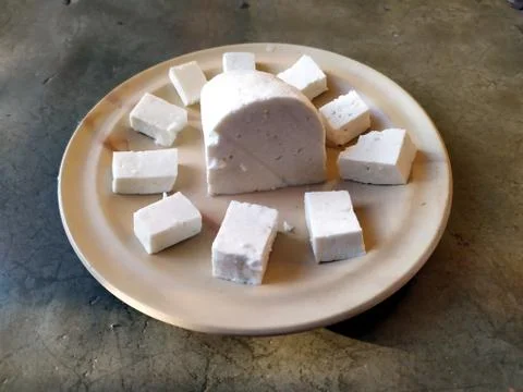 Paneer slice put in a plate with stone background Stock Photos
