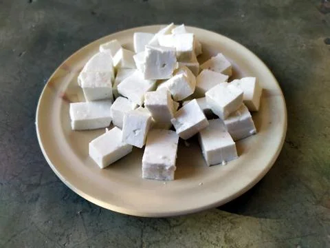 Paneer slice put in a plate with stone background Stock Photos