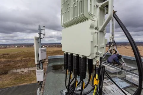 Panel antenna of GSM DCS UMTS LTE bands and outdoor remote radio unit are as Stock Photos
