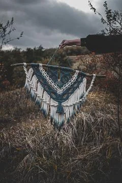 Panel of blue and white macrame on a decorative branch in nature Stock Photos