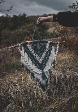 Panel of blue and white macrame on a decorative branch in nature Stock Photos