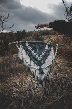 Panel of blue and white macrame on a decorative branch in nature Stock Photos