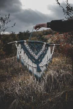 Panel of blue and white macrame on a decorative branch in nature Stock Photos