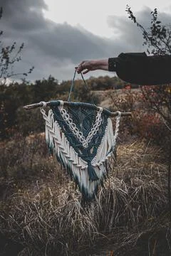 Panel of blue and white macrame on a decorative branch in nature Stock Photos