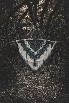 Panel of blue and white macrame on a decorative branch in nature Stock Photos