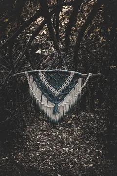 Panel of blue and white macrame on a decorative branch in nature Stock Photos