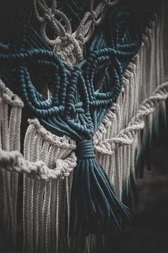 Panel of blue and white macrame on a decorative branch in nature Stock-Fotos