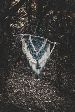 Panel of blue and white macrame on a decorative branch in nature Foto stock