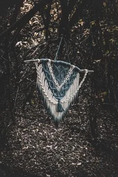 Panel of blue and white macrame on a decorative branch in nature Stock Photos