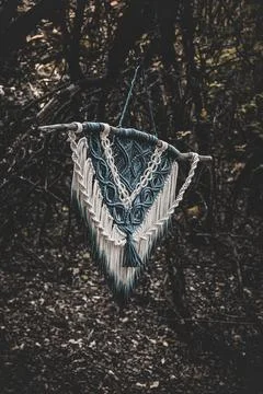 Panel of blue and white macrame on a decorative branch in nature Stock Photos