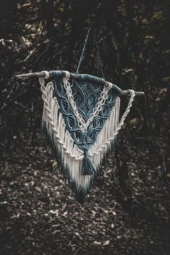 Panel of blue and white macrame on a decorative branch in nature Stock Photos