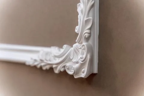The panel is a plaster frame with patterned corners on the wall of the room.  Stockfoto's