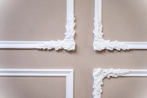 The panel is a plaster frame with patterned corners on the wall of the room.  Stock Photos