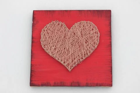 Panels of thread and nails, heart on a red background. string art. gift or de Stock Photos