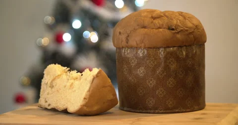 Panettone slice with Christmas tree and blurry lights flashing in the backgroun Video stock 160626460