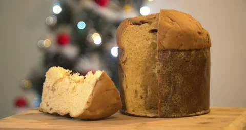 Panettone slice with Christmas tree and blurry lights flashing in the backgroun Video stock 160626599