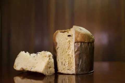Panettone slice on the table. Panettone cut on wooden table and textured back Stock Photos