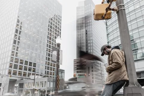Panhandler receiving change from a blurred anonymous pedestrian Stock Photos