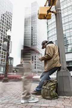 Panhandler receiving change from a blurred pedestrian Stock Photos