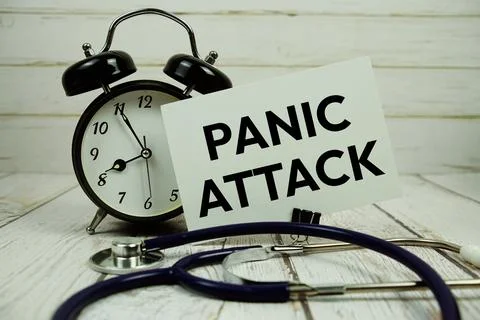 Panic Attacks text on paper card with alarm clock and stethoscope on wooden.. Stock Photos