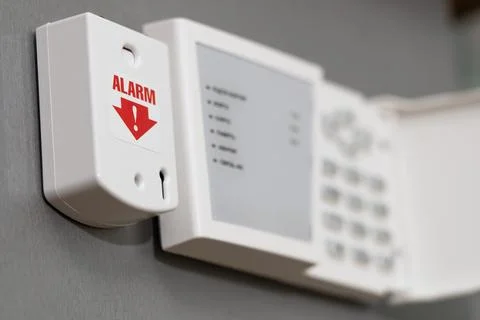 Panic button of security systems on a gray wall, close-up. selective focus. Stock Photos