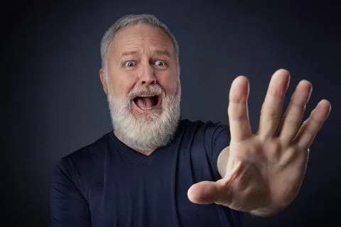 Panicked elderly man with his stretched hand forward Stock Photos