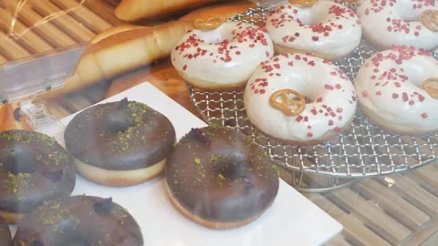 Paning view to the stall of fresh donuts in store through glasses window in.. Stock Footage 254048201