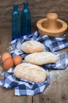 Panini rolls in rustic kitchen setting with cooking utensils Stock Photos