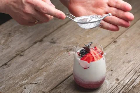 Panna cotta dessert with strawberries, blackberry and powdered sugar on top. Stock Photos