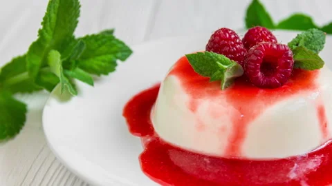 Panna cotta with raspberry, decorated with fresh mint. 库存影片 99748222