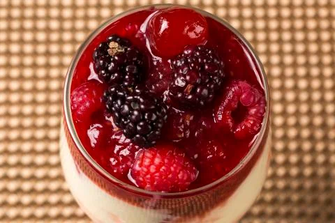 Pannacota dessert covered in raspberry sauce and fresh raspberries topped w.. Stock Photos
