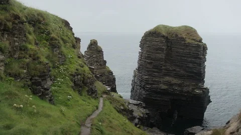 Panning across the cliffs rocks and sea at Castle ruins Stock Footage 111538797