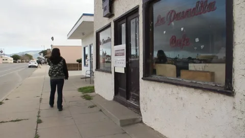 Panning across old restaurant building to person walking Stock Footage 155386552