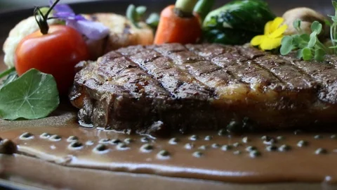 Panning and close up beef steak with vegetables background. Stock Footage 106001046