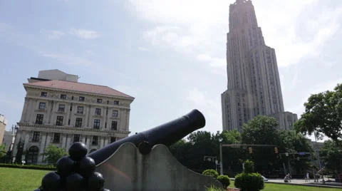 Panning up and down from the Cathedral of Learning to a cannon in Pittsburgh Stock Footage 64894573