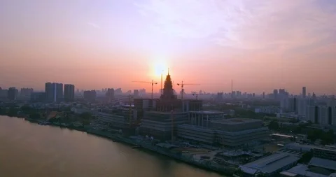 Panning around cranes at construction building mall next to river Stock Footage 108573706