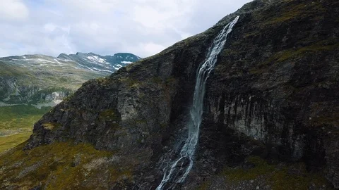 Panning around a stunning dramatic waterfall on a steep vertical cliff Stock Footage 99680914