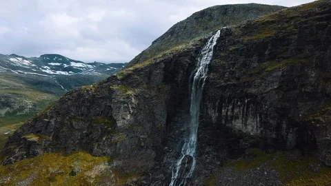 Panning around a stunning dramatic waterfall on a steep vertical cliff Stock Footage 99681175