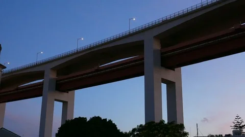 Panning from below of the iconic 25 April bridge in Lisbon, Portugal at sunset Stock Footage 108637754