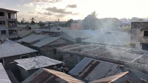 Panning Burning Trash Smoke Pollution Drifting Over Tin Roofs Urban Africa Kenya Vídeo Stock 232295877