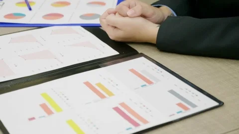 Panning up Businesspeople at a desk office talking and analyzing financial Stock Footage