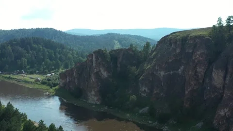 Panning camera view over a serene river and lush forest landscape Vídeo Stock 297741816
