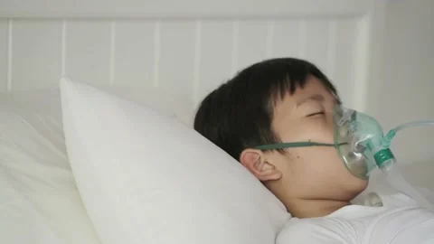 Panning camera Young asian boy with oxygen mask sleep on a bed 스톡 동영상 137158811