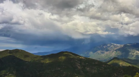 Panning cinematic time lapse of rainy clouds moving fast above green hills Stock Footage 38242290