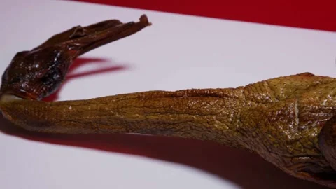 Panning close up of roasted duck neck and head Stock Footage 327911808